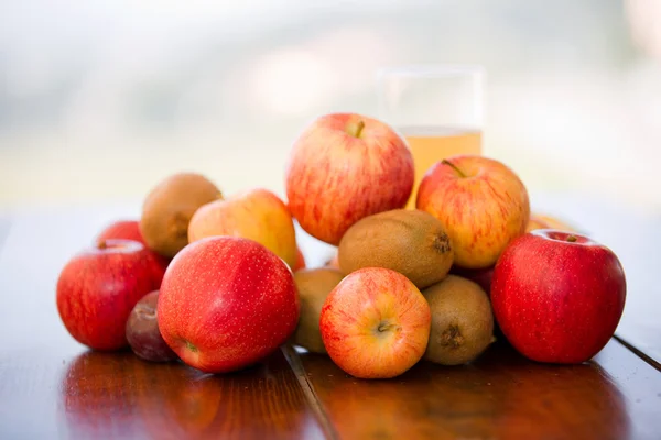 Frutas y jugos en una mesa de madera, al aire libre — Foto de Stock