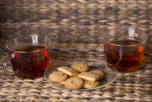 紅茶と木製の背景の前に木製のテーブルの上のクッキー — ストック写真