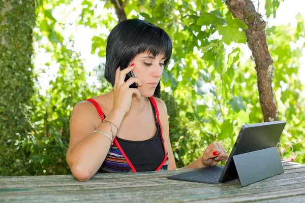 Casual kvinna som arbetar med en TabletPC, utomhus — Stockfoto