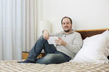 casual adam yatakta bir tablet pc ile çalışma