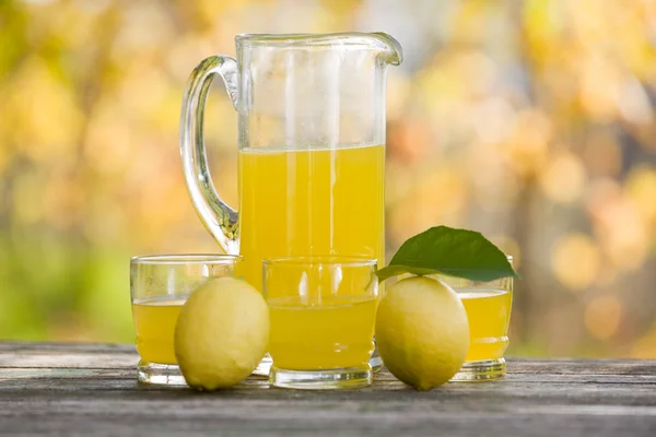 Zitronensaft auf Holztisch, Herbstset, draußen — Stockfoto