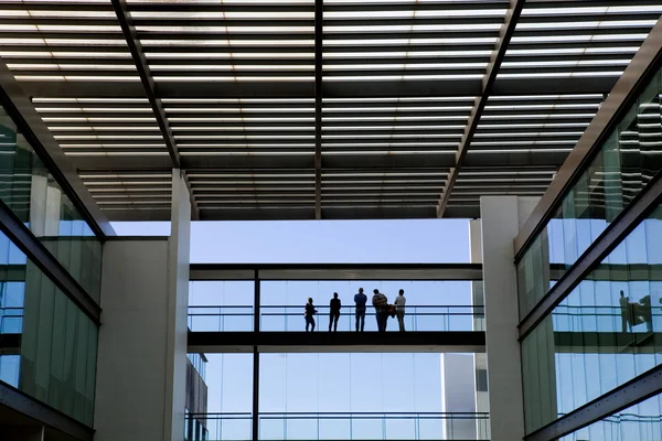 Bazı insanlar bir modern ofis binası iç görünümünü siluet — Stok fotoğraf