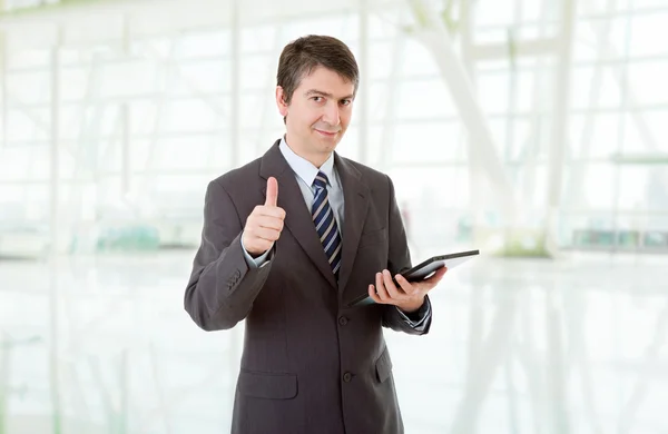 Geschäftsmann, der im Büro mit einem Tablet-PC Daumen nach oben drückt — Stockfoto