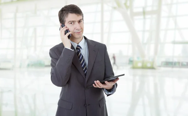 Hombre de negocios usando el cojín táctil de la tableta PC, en el teléfono, en la oficina — Foto de Stock