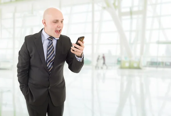 Angry businessman yelling into a cellphone, at the office — Stock Photo, Image