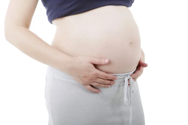 Closeup těhotná žena v bílém pozadí — Stock fotografie