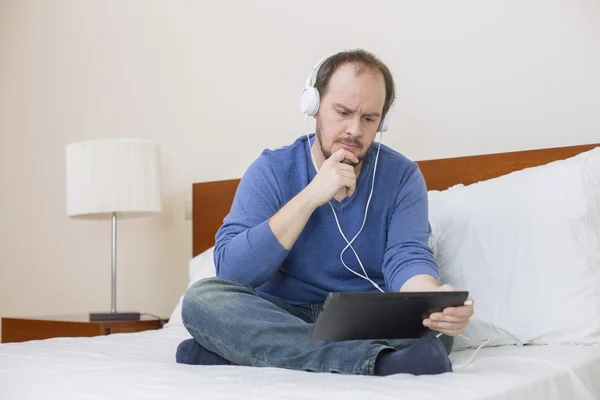 Gelegenheitsmann arbeitet mit Tablet-PC im Bett — Stockfoto