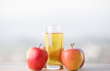 Elma ve elma suyu ahşap bir masada, açık havada.