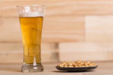 Ahşap masa, hareketsiz yaşam tarzı üzerinde kavrulmuş fıstık ile soğuk bira