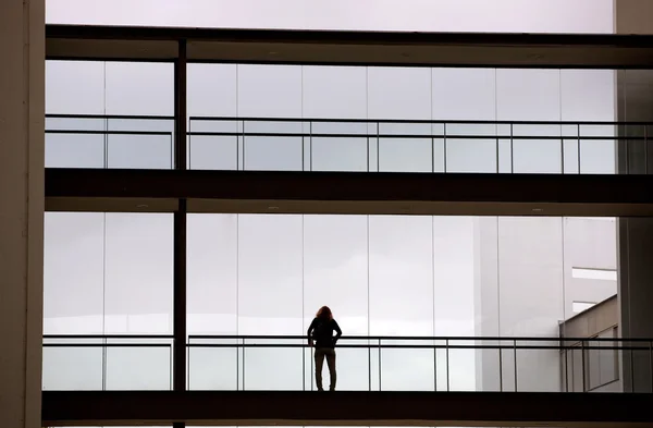 Vista silhueta de uma jovem empresária num moderno edifício de escritórios interior — Fotografia de Stock