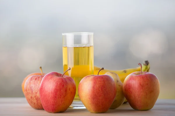 Buah-buahan dan jus apel di atas meja kayu, luar ruangan — Stok Foto