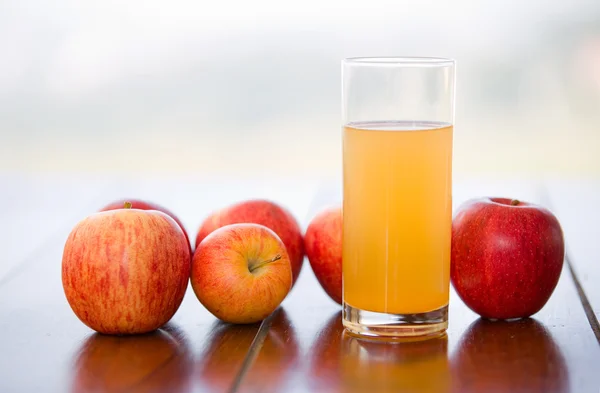 Jabłka i sok na drewnianym stole, odkryty — Zdjęcie stockowe