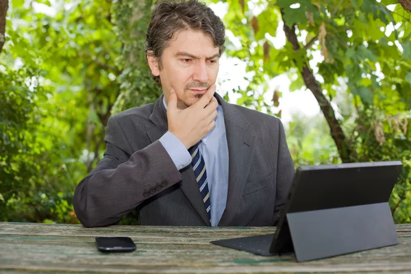 Worried businessman with digital tablet, outdoors — Stock Photo, Image