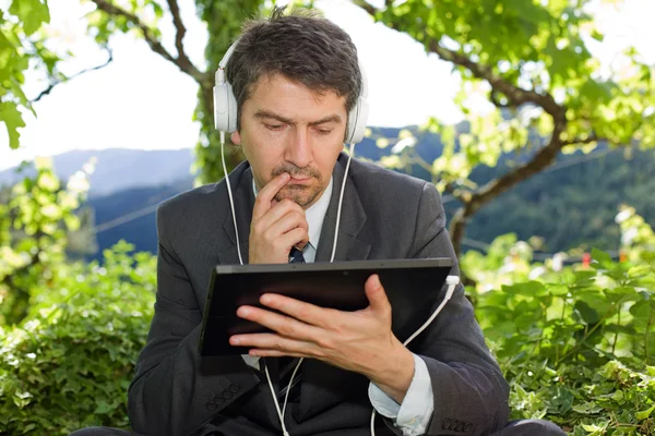 Pensive businessman with digital tablet, outdoors — Stock Photo, Image