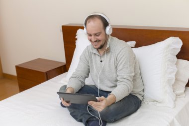 casual adam yatakta bir tablet pc ile çalışma