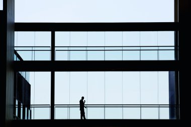 Modern ofis binası içinde genç işkadını görünümünü siluet