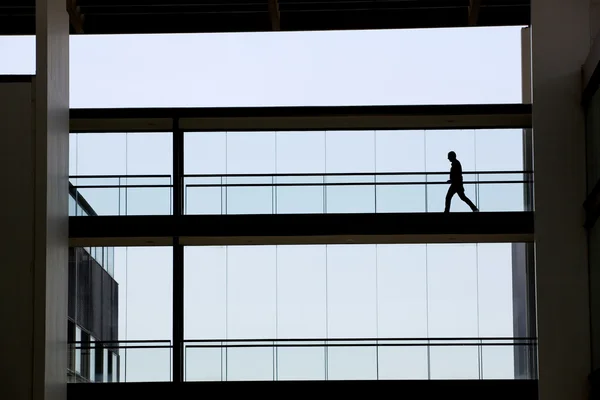 Silhouet weergave van jonge zakenman in een modern kantoorgebouw interieur — Stockfoto