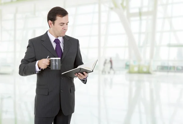 Nadenkend zakenman met een boek op het Bureau — Stockfoto