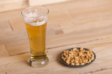 Ahşap masa, hareketsiz yaşam tarzı üzerinde kavrulmuş fıstık ile soğuk bira