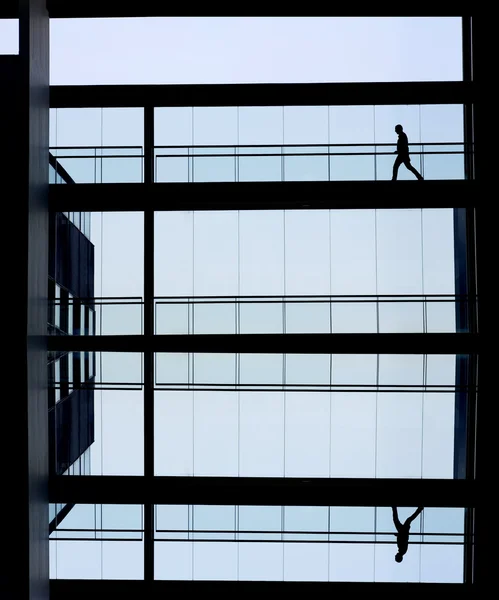 Vista silhueta de um jovem empresário num moderno edifício de escritórios interior — Fotografia de Stock