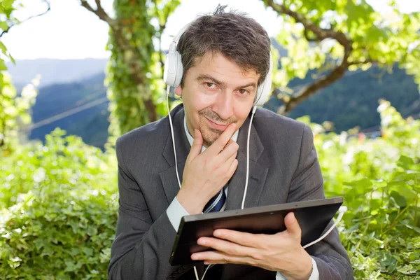 Uomo d'affari pensieroso con tablet digitale, all'aperto — Foto Stock