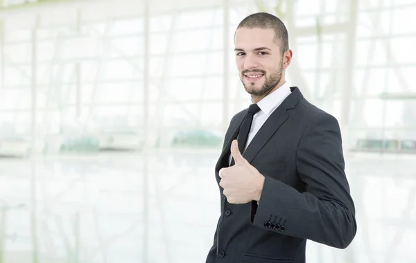 Молодой бизнесмен поднимает большой палец, в офисе — стоковое фото