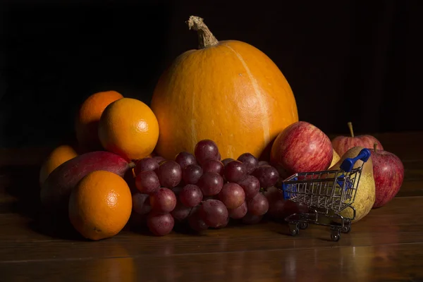 Разнообразие фруктов и небольшая корзина для покупок на водяном столике, студийное фото — стоковое фото