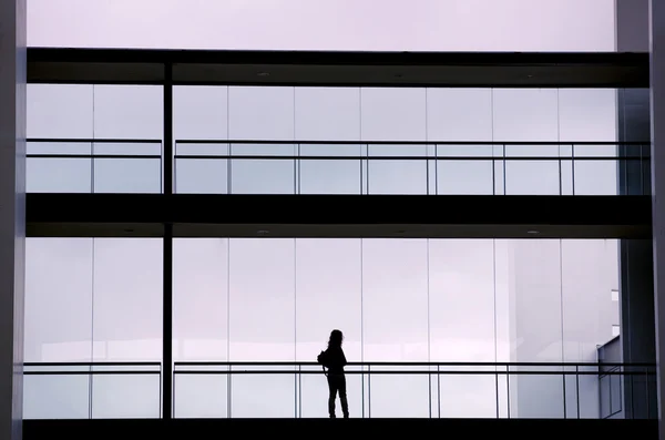 Vue en silhouette d'une jeune femme d'affaires dans un immeuble de bureaux moderne intérieur — Photo