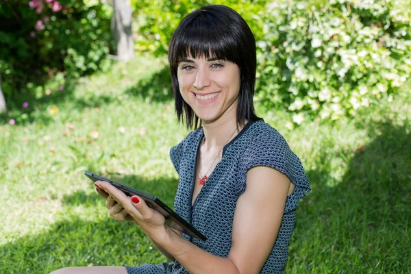 Femme occasionnelle travaillant avec une tablette pc, en plein air — Photo