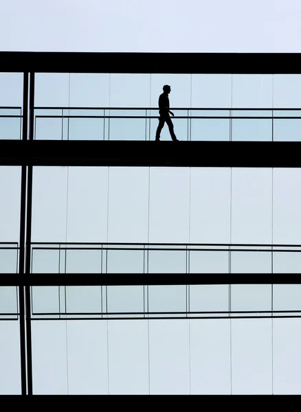 Vista de la silueta del joven empresario en un moderno edificio de oficinas interior —  Fotos de Stock