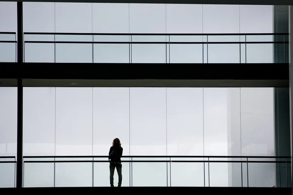 현대 오피스 빌딩 내부에 젊은 사업가의 실루엣 보기 — 스톡 사진