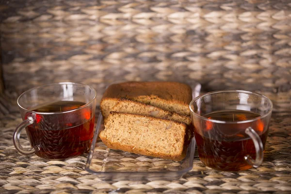Te och kaka på träbord framför en trä bakgrund — Stockfoto