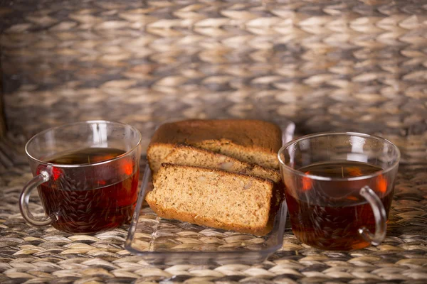 Thé et gâteau sur table en bois devant un fond en bois — Photo