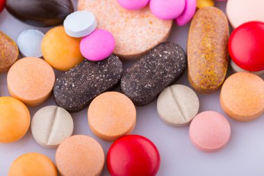 Haplar, kapsül yığını, karışık terapi ilaçları, beyaz bir arka plan.