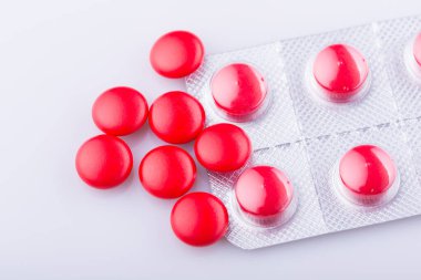 Haplar, kapsül yığını, karışık terapi ilaçları, beyaz bir arka plan.