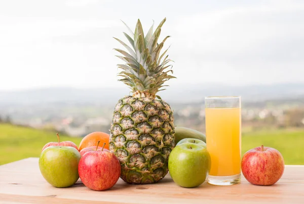 Glas Apelsinjuice Och Massor Frukt Träbord Utomhus — Stockfoto