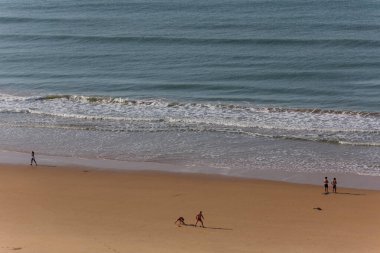 PRAIA DA ROCHA, PORTUGAL: Portimao Praia da Rocha 'nın ünlü plajında insanlar. Bu plaj Algarve 'nin ünlü turistik bölgesinin bir parçasıdır..