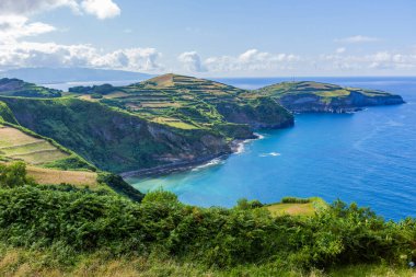 Azores 'deki So Miguel adasındaki Miradouro de Santa Iria' dan görüntü. Manzara, kuzey kıyı şeridinin bir kısmını uçurumlar ve yeşil alanlarla gösteriyor.