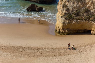 PRAIA DA ROCHA, PORTUGAL: Portimao Praia da Rocha 'nın ünlü plajında insanlar. Bu plaj Algarve 'nin ünlü turistik bölgesinin bir parçasıdır..