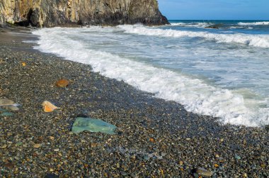 Rocky Rugged Plajı 'nda güneşli bir gün Bakır Sahili, İrlanda' da okyanusa bakıyor.