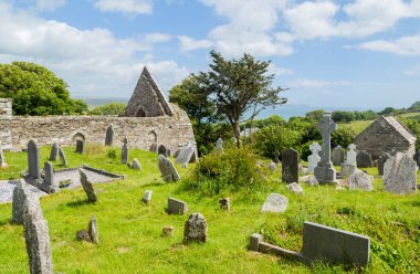 Yuvarlak taş kule ve 6. yüzyılda Glendalough Vadisi, Wicklow, İrlanda 'da inşa edilmiş bir manastır yerleşiminin kalıntıları..