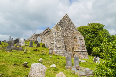 Taştan kule ve 6. yüzyılda Glendalough Vadisi, Wicklow, İrlanda 'da inşa edilmiş bir manastır yerleşiminin kalıntıları..