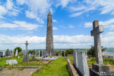 Yuvarlak taş kule ve 6. yüzyılda Glendalough Vadisi, Wicklow, İrlanda 'da inşa edilmiş bir manastır yerleşiminin kalıntıları..