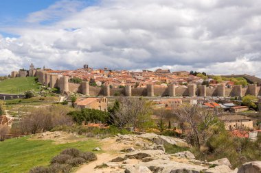 İspanya 'nın Cuatro Postes kentinin Mirador' undan ünlü ortaçağ kasaba duvarlarıyla tarihi Avila kentinin panoramik manzarası. UNESCO Dünya Mirası