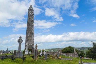 Yuvarlak taş kule ve 6. yüzyılda Glendalough Vadisi, Wicklow, İrlanda 'da inşa edilmiş bir manastır yerleşiminin kalıntıları..