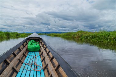 Myanmar 'daki Inle Gölü' nü eski ve paslı bir tekneyle keşfediyor.