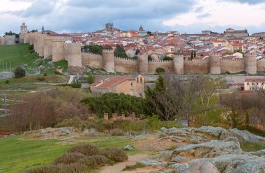 İspanya 'nın Cuatro Postes kentinin Mirador' undan ünlü ortaçağ kasaba duvarlarıyla tarihi Avila kentinin panoramik manzarası. UNESCO Dünya Mirası