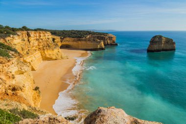 Praia da Marinha 'nın ünlü sahilinde dalgalar. Bu plaj Algarve 'nin ünlü turistik bölgesinin bir parçasıdır..
