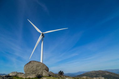 Portekiz 'in Fafe kenti yakınlarında temiz ve yenilenebilir enerji üretimi için tepenin üstündeki rüzgar türbini jeneratörü.