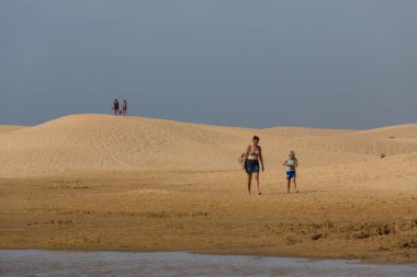 PRAIA DA BORDEIRA, PORTUGAL: Praia da Bordeira 'nın ünlü plajının kumullarında insanlar. Bu plaj Algarve 'nin ünlü turistik bölgesinin bir parçasıdır..
